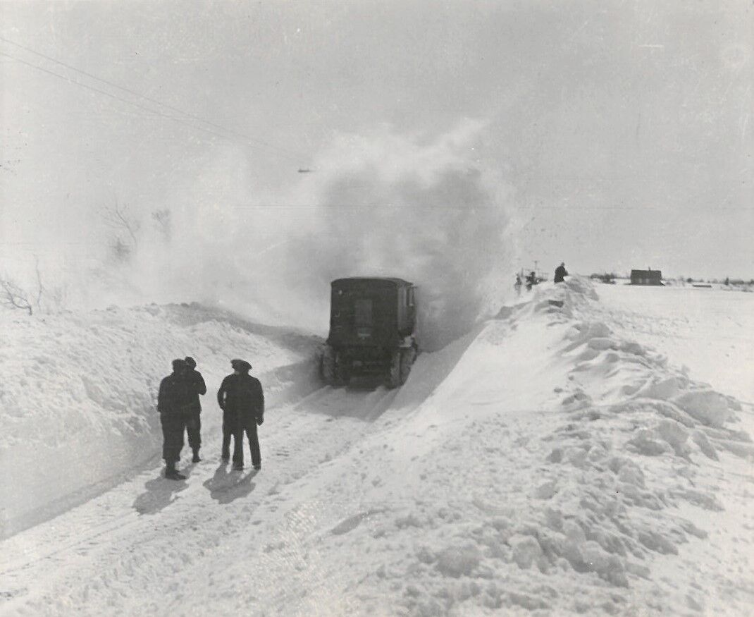 A rotary hitting a badly drifted road, undated